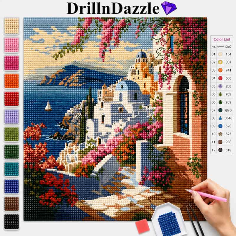 A colorful diamond painting or cross-stitch style art kit showing a scenic coastal village scene with blue sea, white buildings, pink flowers, and a warm archway. The image includes a color list chart on the right, a vertical row of color swatches on the left, the brand name DrillInDazzle at the top, and a hand holding a pink needle on a small palette at the bottom right.