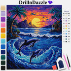 DrillInDazzle diamond painting kit featuring a colorful sunset beach scene with two dolphins leaping in the ocean. The image includes a color list on the right and a vertical row of color swatches on the left, with two paint pens and a brush shown in the bottom right corner.