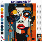 DrillnDazzle diamond painting canvas featuring a colorful abstract portrait of a woman's face with glasses, shown with a color chart and paint tools on a white background.