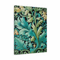 A vertical canvas wall art print featuring a classic William Morris-style botanical pattern with teal, green, and gold leaves and flowers on a black background, shown at a slight angle against a plain white studio backdrop.
