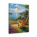 A rectangular canvas wall art print showing a colorful lakeside garden scene with two wooden Adirondack chairs in the foreground, flowers, trees, water, and a dramatic sunlit sky. The canvas is photographed at a slight angle against a plain white background.