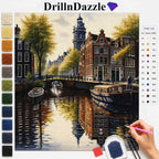 DrillnDazzle diamond painting kit showing a completed Amsterdam canal scene with a color list chart on the right and a hand holding a pink pencil pointing to the canvas.
