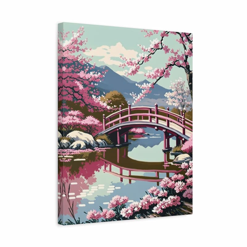 A rectangular canvas wall art print showing a stylized landscape with a pink arched bridge over reflective water, surrounded by pink cherry blossoms and distant blue mountains.
