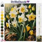 A diamond painting or cross-stitch style floral design showing white and yellow daffodils with green stems and leaves, alongside a color palette strip and a reference number chart. The brand name DrillInDazzle appears at the top with a small diamond icon.