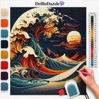 A diamond painting kit layout featuring a stylized wave artwork inspired by The Great Wave off Kanagawa. The image shows the completed artwork preview, a color list chart on the right, a vertical row of color swatches on the left, a DrillnDazzle logo at the top, and a hand holding a pink needle on the lower right.