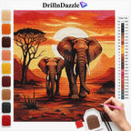 A diamond painting kit showing a completed safari art piece with two elephants under a bright sun, alongside a color list, paintbrush, beads, and a hand holding a pink paintbrush. The brand name DrillInDazzle is visible at the top.