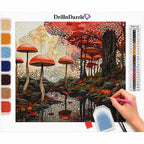 A diamond painting kit by DrillnDazzle showing a forest scene with red mushrooms, trees, and a pond, with a hand holding a pink pen painting on it. Color swatches are shown on the left, a color list on the right, and the brand name DrillnDazzle at the top.
