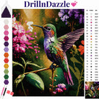 A colorful diamond painting art kit cover showing a hummingbird perched among pink flowers, with the DrillnDazzle brand name at the top, a color chart on the right, and sample color swatches on the left.