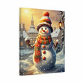 A vertical canvas wall art print depicting a whimsical winter village scene with a snowman in the foreground. The snowman wears a striped beanie with a red pom-pom, a red, green, and orange striped scarf, and has snow buttons.