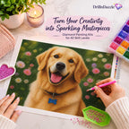 A person's hands are shown painting a golden retriever portrait using a diamond painting kit, with a pink diamond pen and a green bead holder. The scene is styled as a flat-lay on a white desk with a candle, a potted plant, and a box of colorful beads.